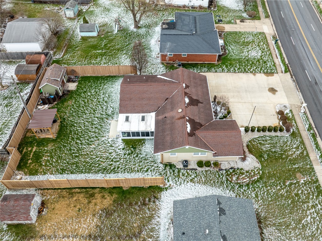 305 South Vandemark Road Sidney, OH 45365 - Photo 4 of 32 An aerial view showcases a residential property with a fenced yard and detached shed.
