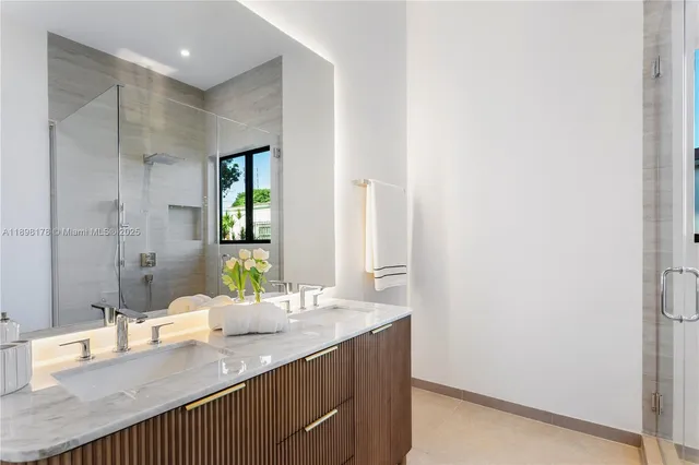 a bathroom with a granite countertop sink a mirror and a shower