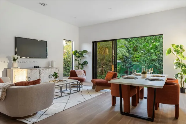 a living room with furniture a flat screen tv and a floor to ceiling window