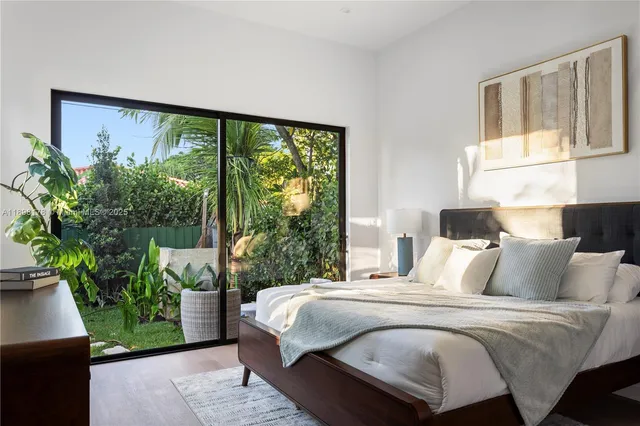 a bedroom with a large bed and a potted plant
