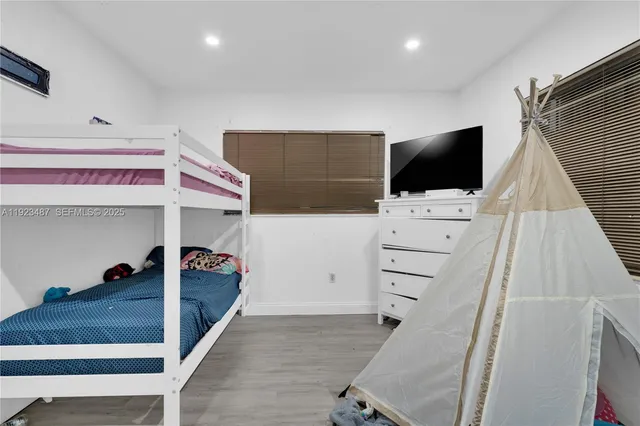 a backyard of a house with table and chairs and wooden fence