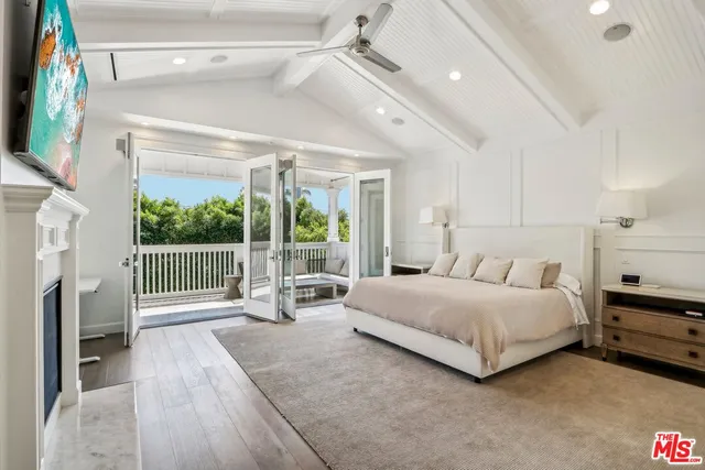 a spacious bedroom with a bed and a flat tv screen