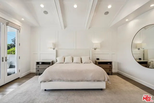 a spacious bedroom with a large bed and a chandelier