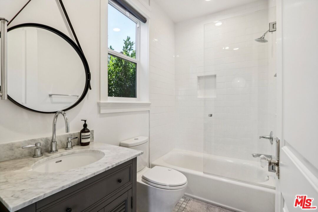 14000 Morrison Street Sherman Oaks, CA 91423 - Photo 28 of 34 a bathroom with a granite countertop toilet a sink and a mirror