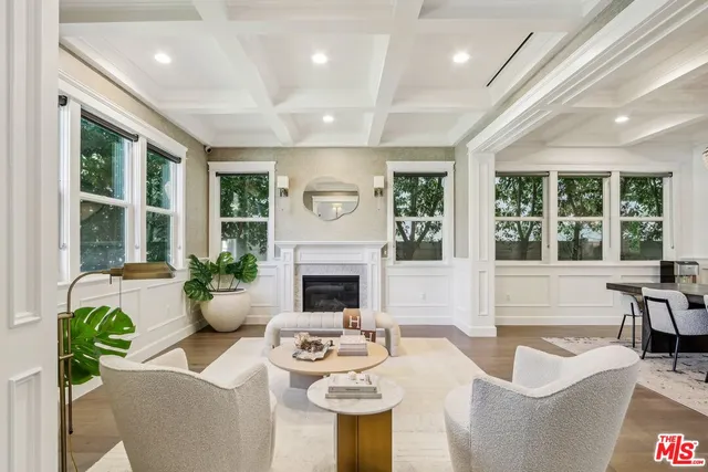 a living room with fireplace furniture and a large window