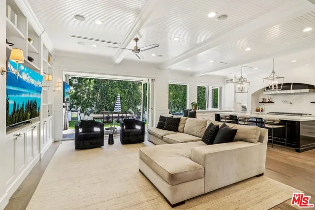 a living room with furniture large window and flat screen tv