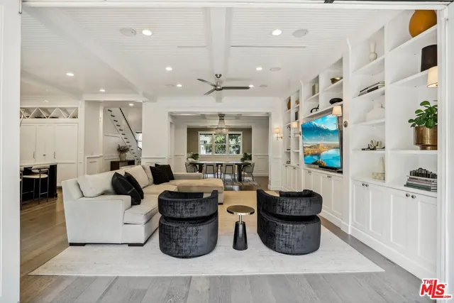 a living room with lots of furniture and a painting on the wall