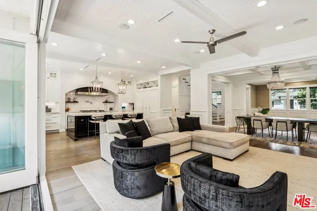 a living room with furniture and a view of kitchen
