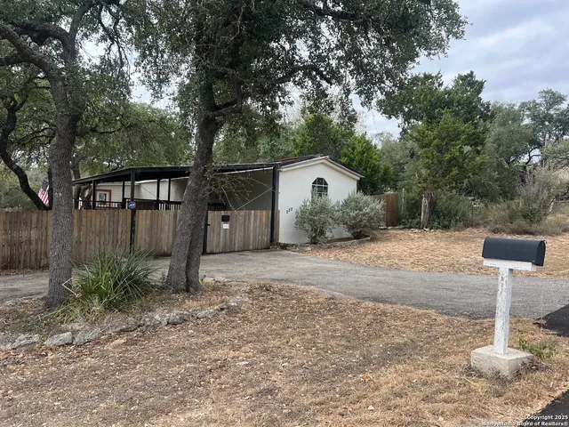 a white house that has a tree in front of it