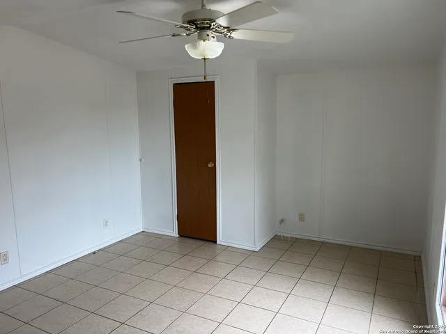 an empty room with a chandelier fan