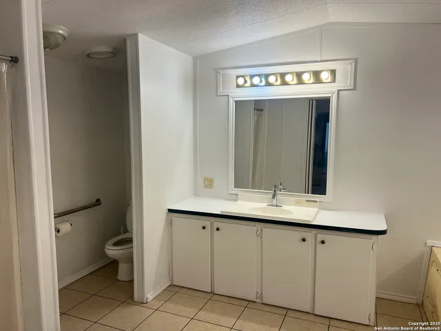 a bathroom with a sink a toilet and a mirror