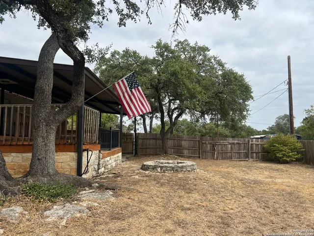 a backyard of a house with barbeque oven table and chairs