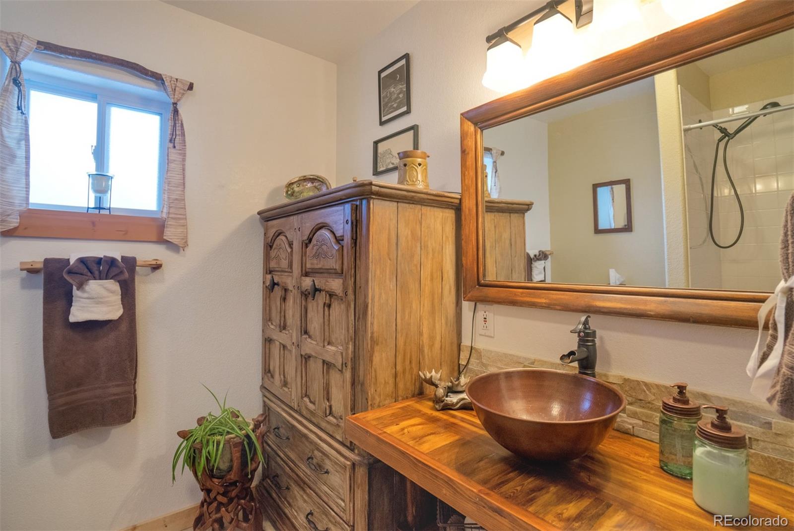 10424 Ranch Road Hartsel, CO 80449 - Photo 15 of 31 a bathroom with a sink a toilet and mirror