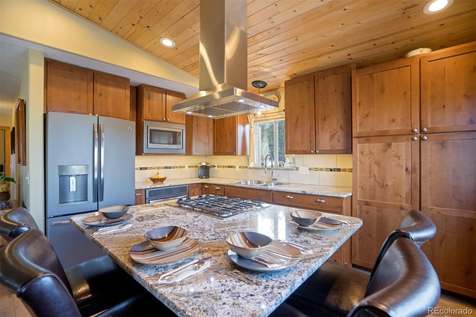 10424 Ranch Road Hartsel, CO 80449 - Photo 5 of 31 a kitchen with a table chairs and a refrigerator