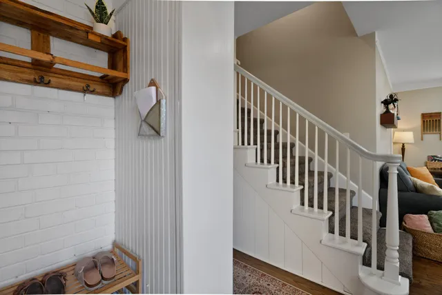 a view of staircase with railing and white walls