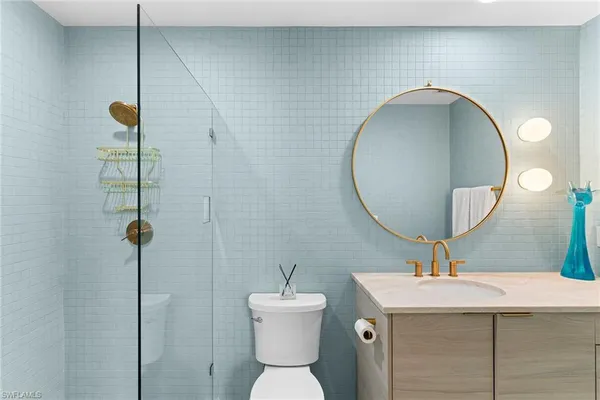 a bathroom with a toilet a sink and mirror