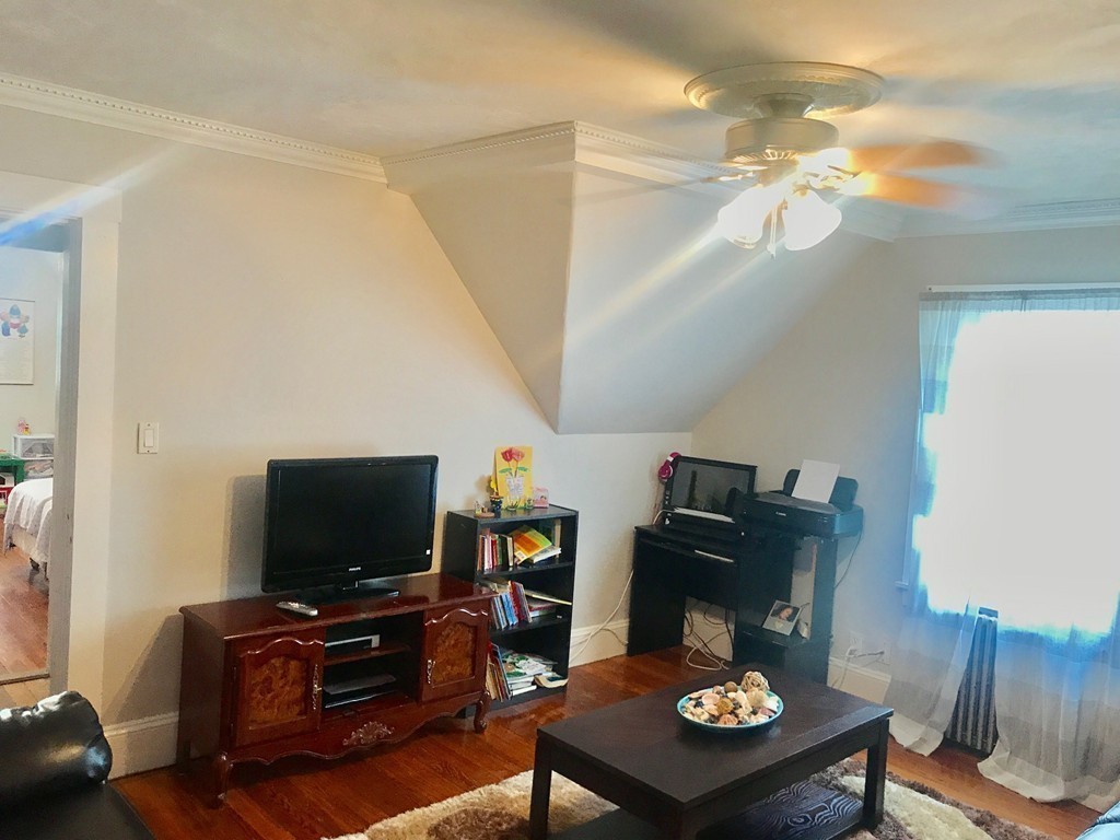 193 Hamilton Street, Unit 3 Boston, MA 02122 - Photo 4 of 8 a living room with furniture and a flat screen tv