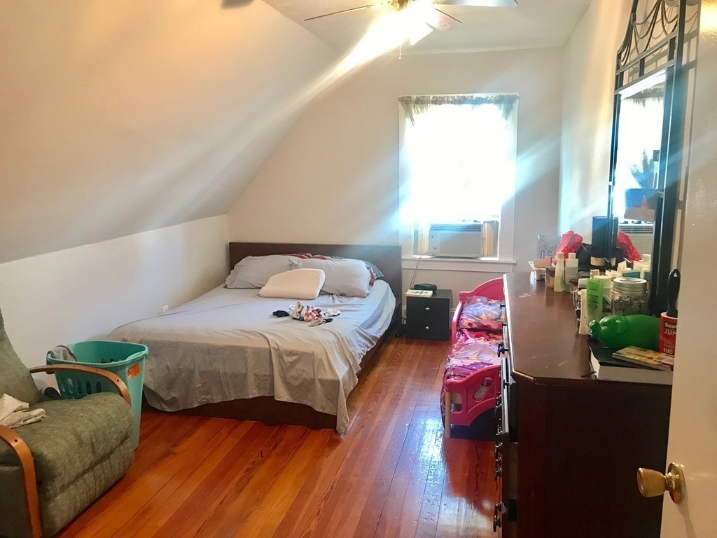 193 Hamilton Street, Unit 3 Boston, MA 02122 - Photo 5 of 8 a bedroom with a bed potted plant on the dresser and floor