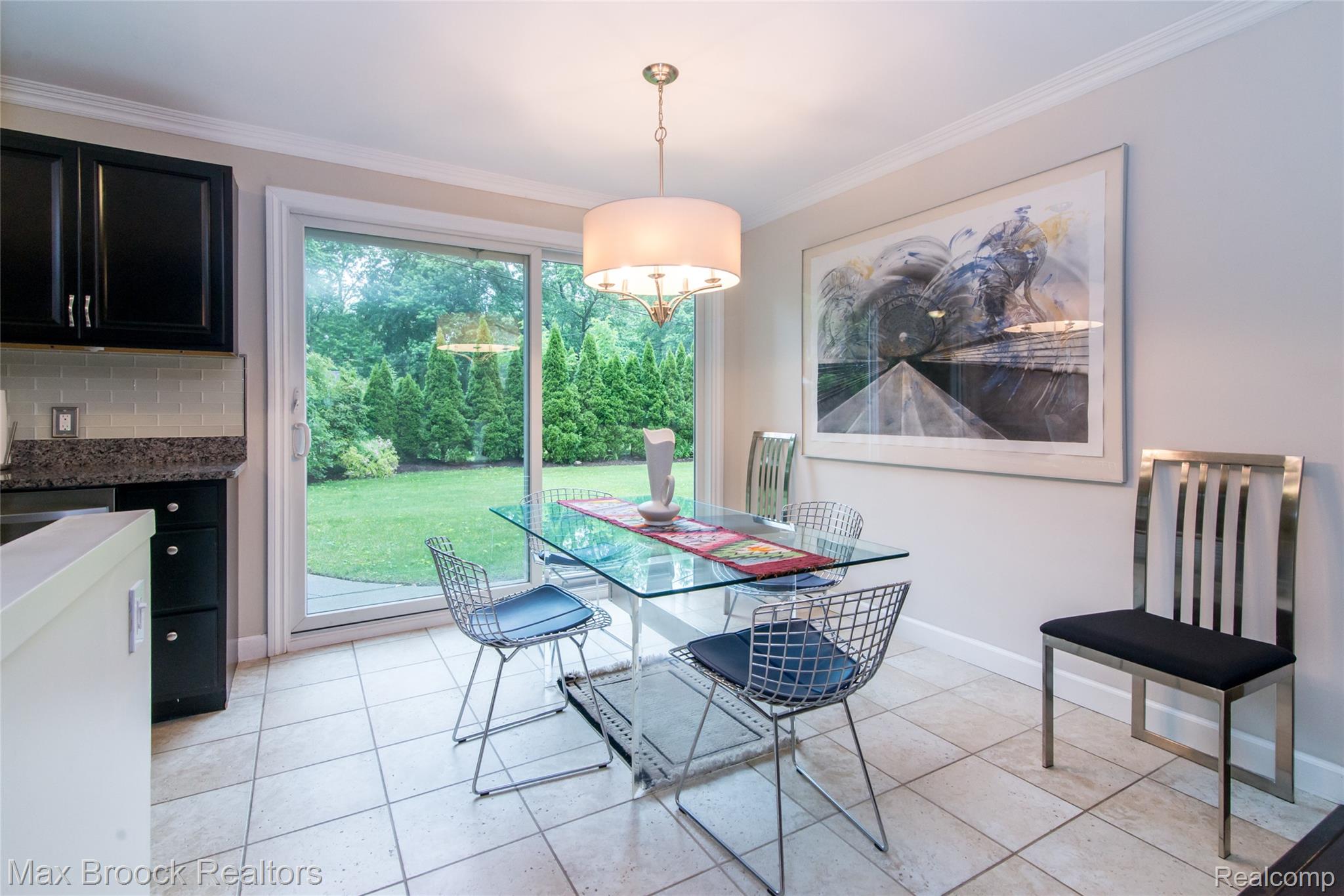 6799 East Dartmoor Road West Bloomfield, MI 48322 - Photo 6 of 36 Dining area featuring light-toned tile flooring, crown molding, and a sliding glass door providing access to the exterior