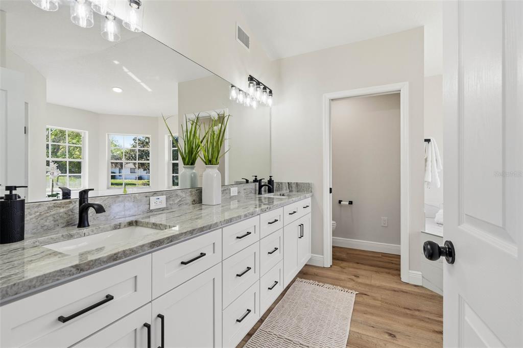 10185 Sleepy Willow Court Spring Hill, FL 34608 - Photo 24 of 44 a bathroom with double vanity sink a two mirror a window and a bathtub