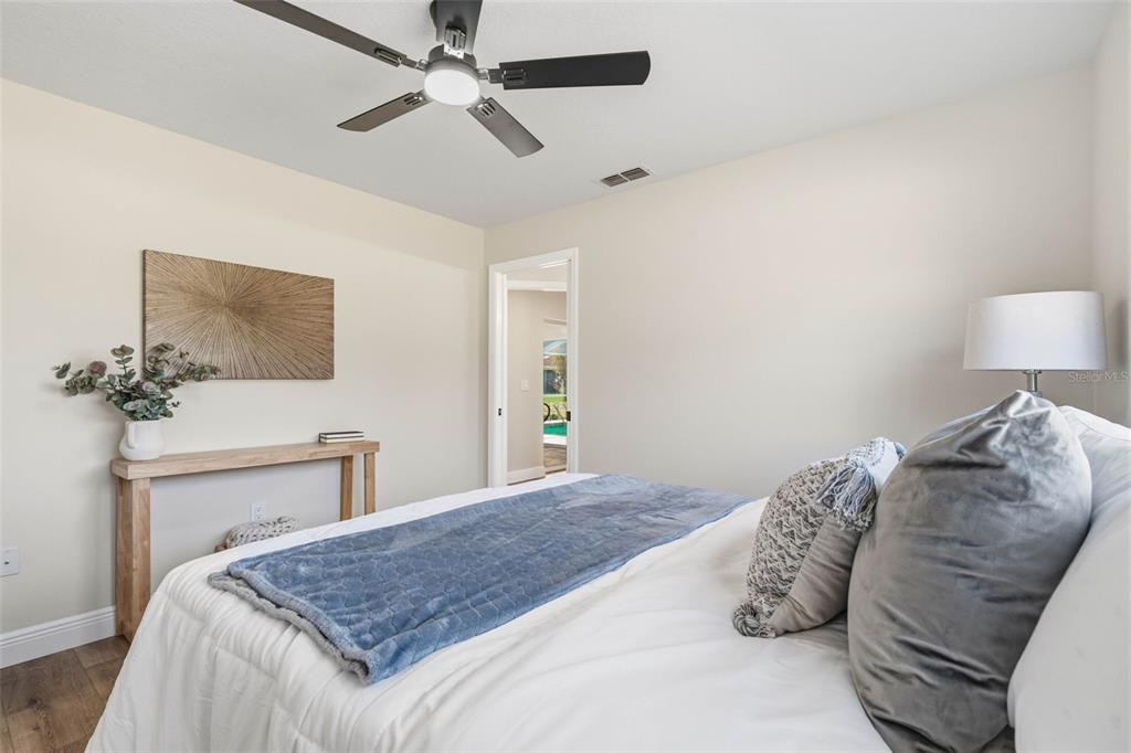 10185 Sleepy Willow Court Spring Hill, FL 34608 - Photo 29 of 44 a bedroom with a bed and a chandelier