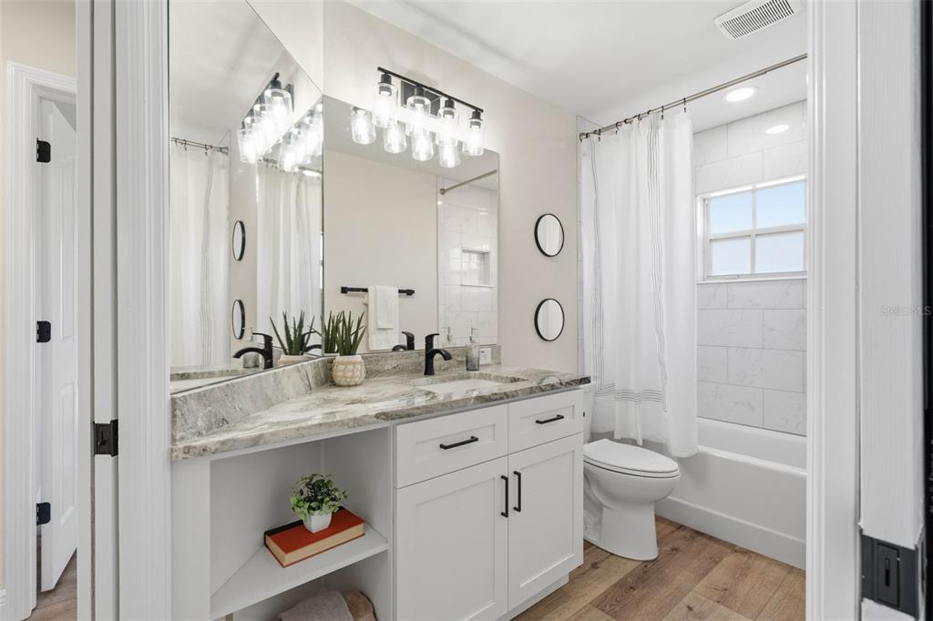 10185 Sleepy Willow Court Spring Hill, FL 34608 - Photo 31 of 44 a bathroom with a granite countertop sink a toilet and a mirror