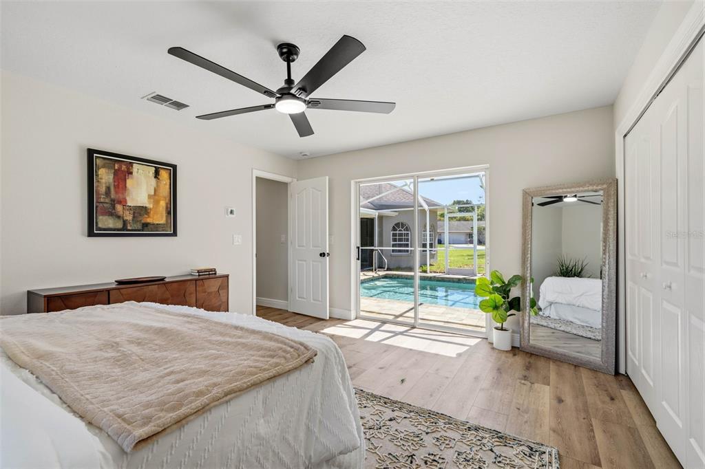 10185 Sleepy Willow Court Spring Hill, FL 34608 - Photo 35 of 44 a bedroom with a bed and a large mirror