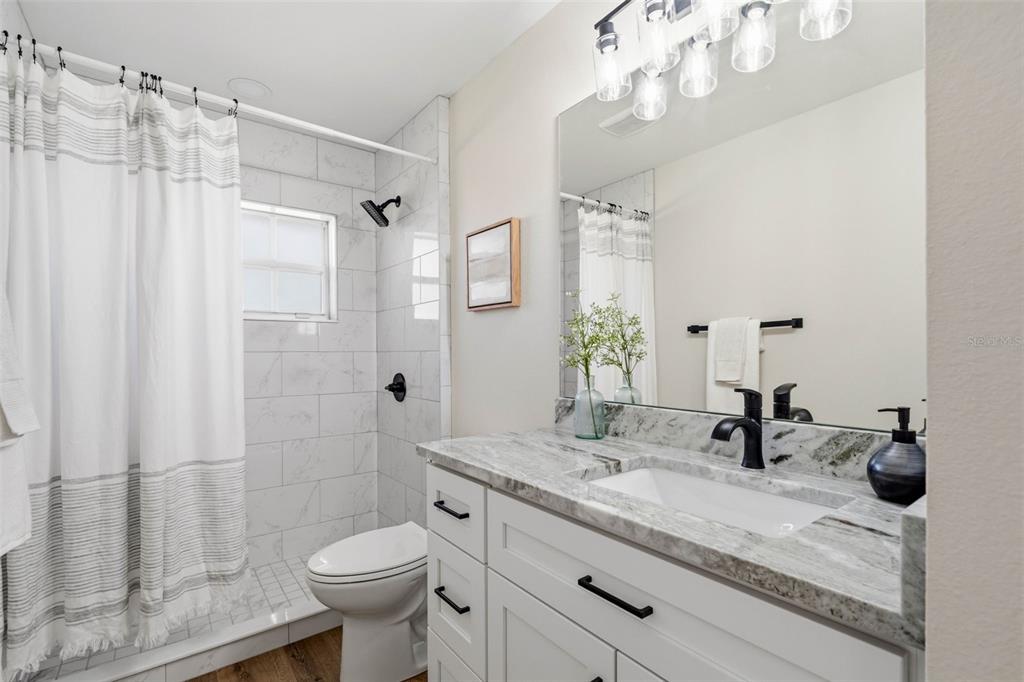 10185 Sleepy Willow Court Spring Hill, FL 34608 - Photo 36 of 44 a bathroom with a sink a toilet and shower