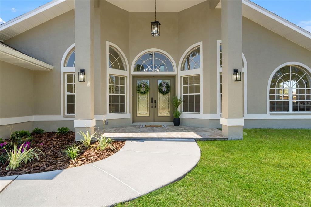 10185 Sleepy Willow Court Spring Hill, FL 34608 - Photo 5 of 44 front view of a house with a garden