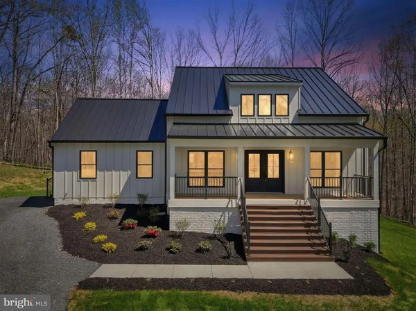 a front view of a house with yard and trees