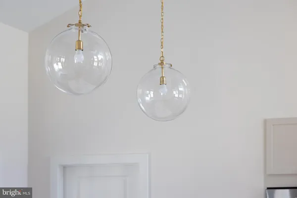 a view of an empty room with a kitchen and a window