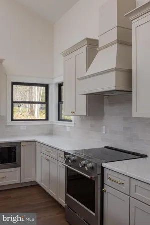 a view of an empty room with wooden floor and window