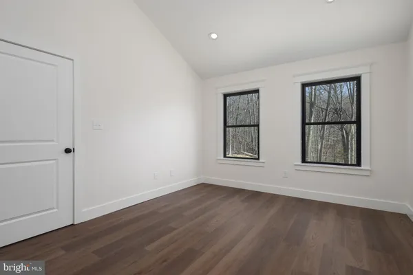 a view of a room with wooden floor and windows