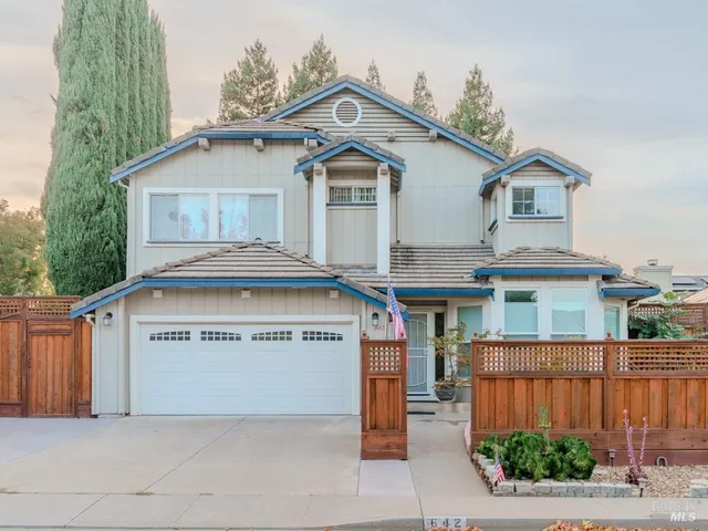 a view of a house with a garage and yard