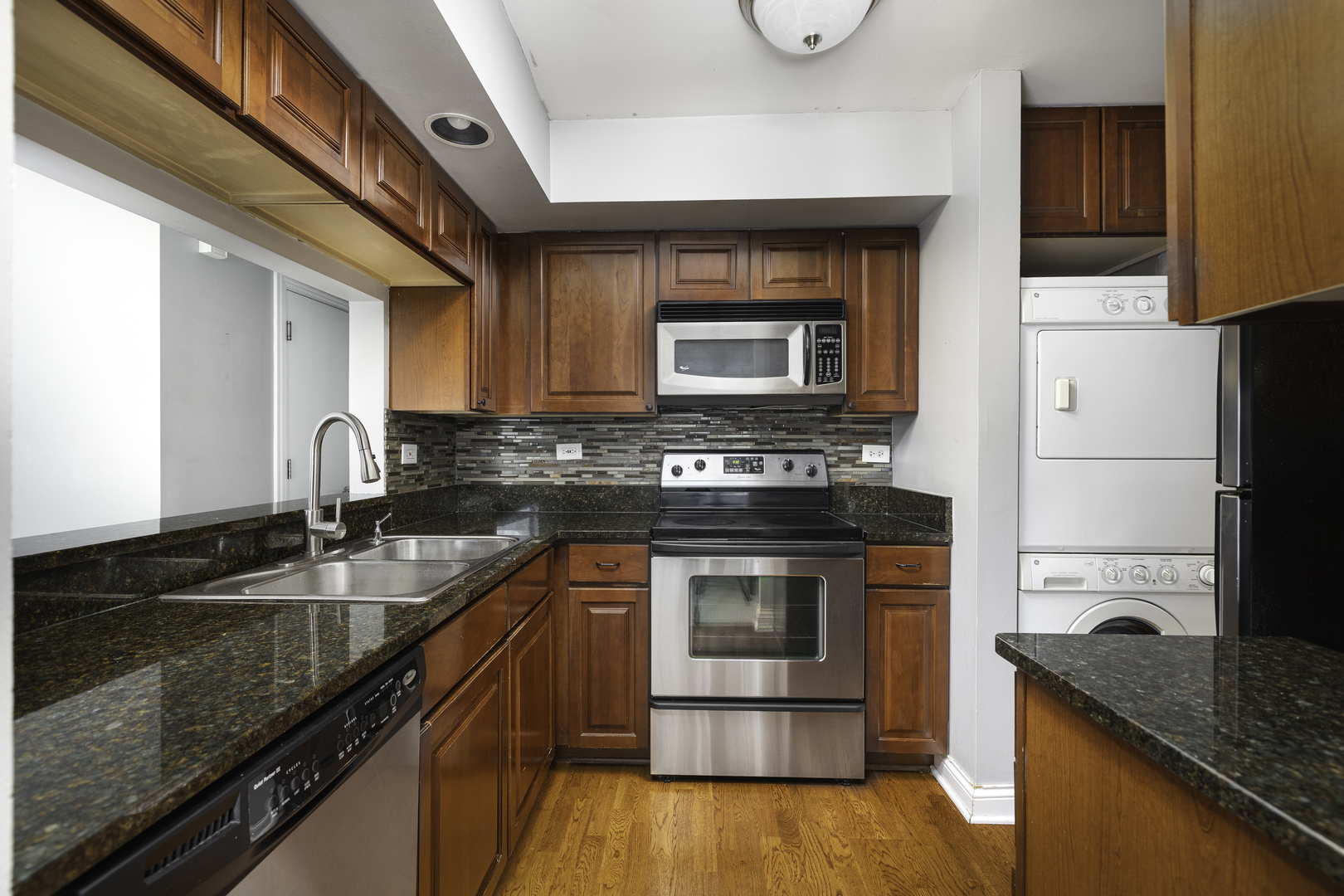 19 Foxcroft Road, Unit 203 Naperville, IL 60565 - Photo 4 of 29 a kitchen with granite countertop a stove sink and cabinets