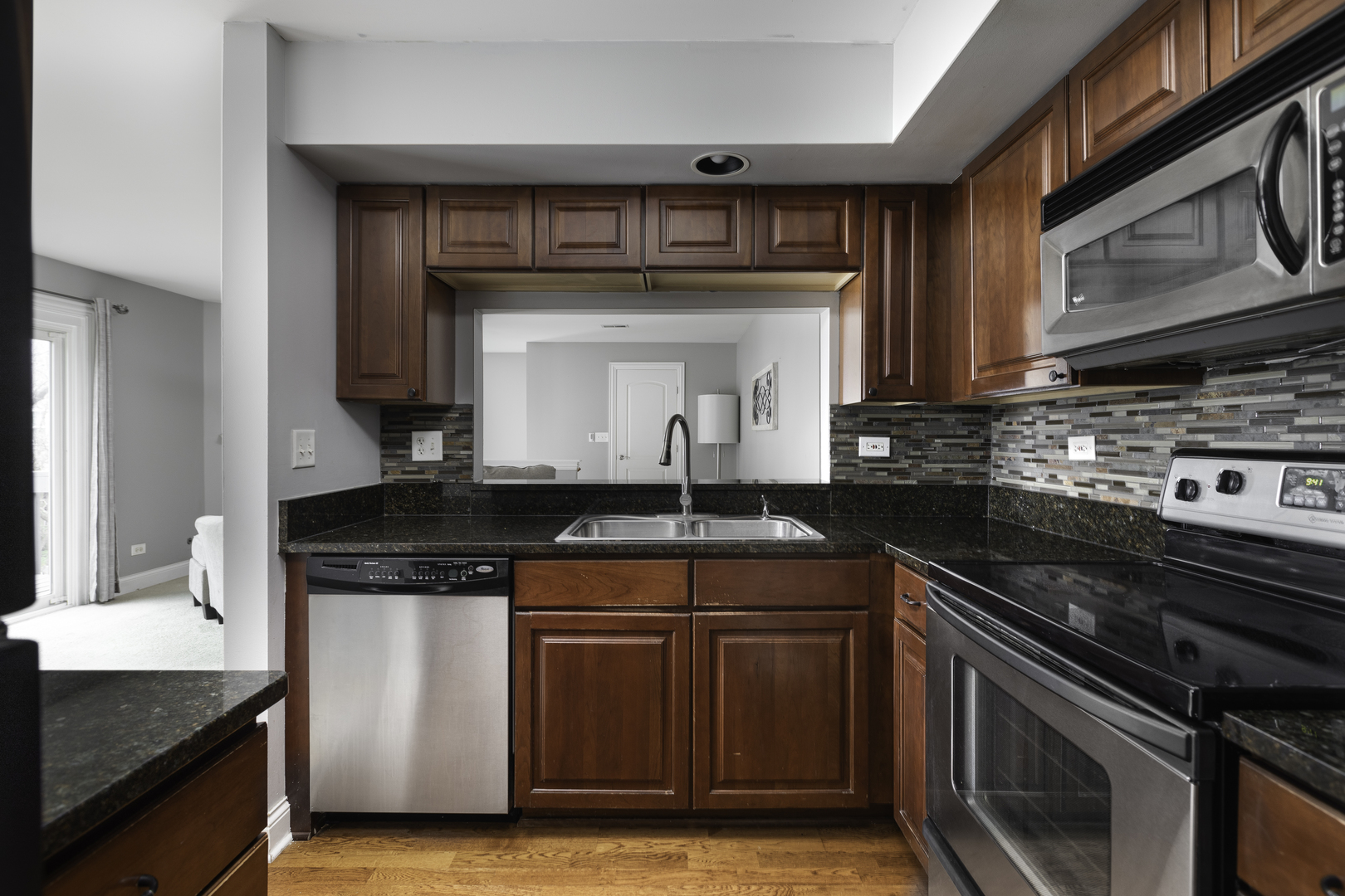 19 Foxcroft Road, Unit 203 Naperville, IL 60565 - Photo 6 of 29 a kitchen with granite countertop a stove sink and cabinets