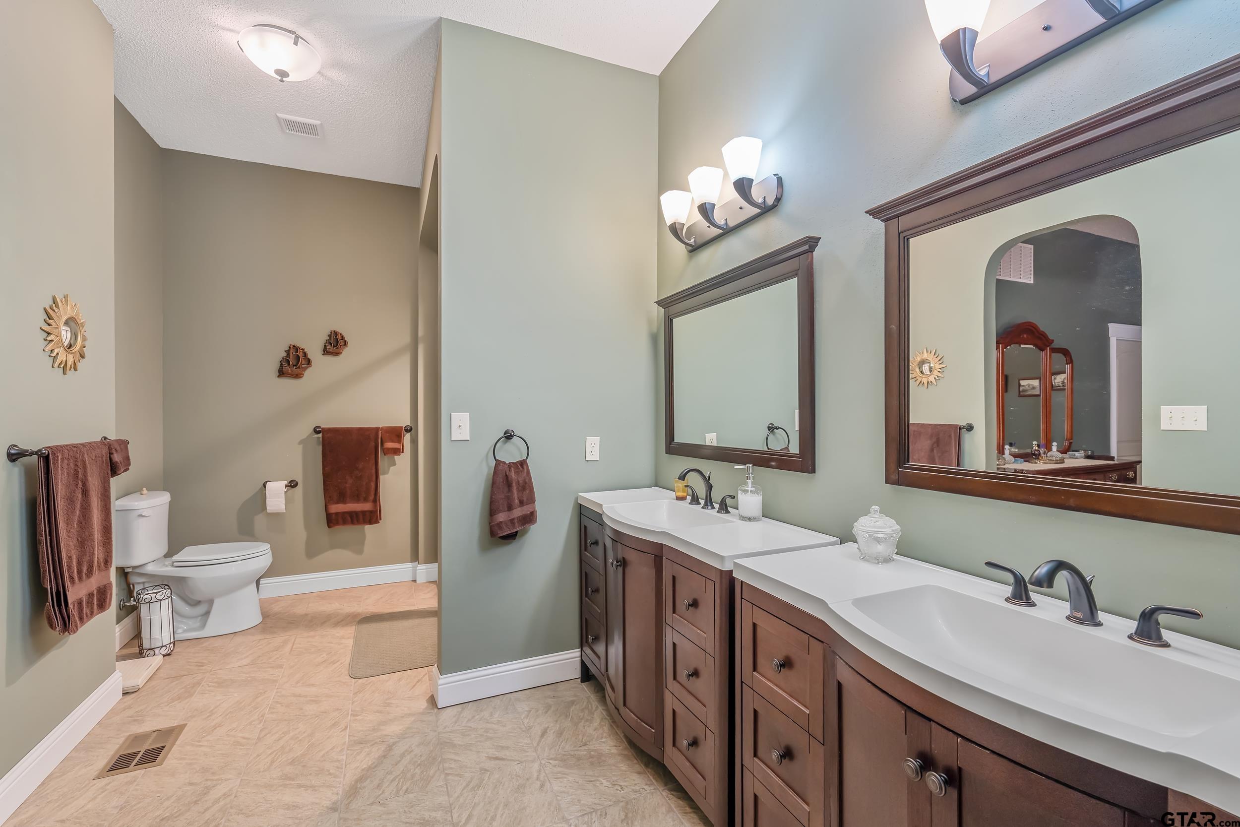 14375 County Road 384 Tyler, TX 75708 - Photo 18 of 48 a spacious bathroom with a double vanity sink a toilet a mirror and shower