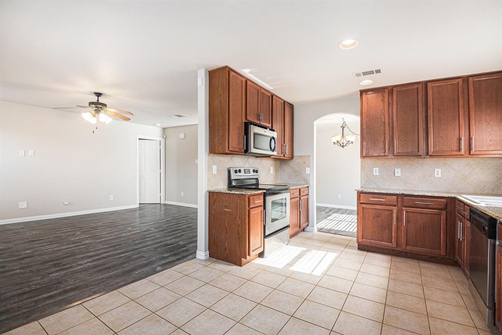 8313 Water Buck Run Fort Worth, TX 76179 - Photo 13 of 25 a large kitchen with stainless steel appliances granite countertop a sink and cabinets