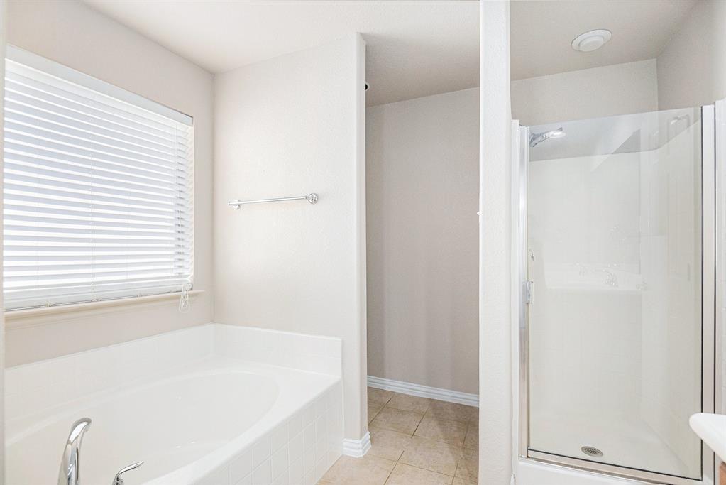 8313 Water Buck Run Fort Worth, TX 76179 - Photo 17 of 25 a white bath tub sitting in a bathroom next to a window