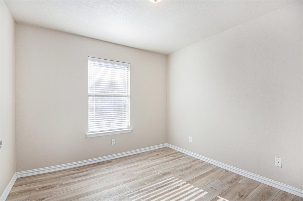 8313 Water Buck Run Fort Worth, TX 76179 - Photo 18 of 25 a view of an empty room with wooden floor and a window
