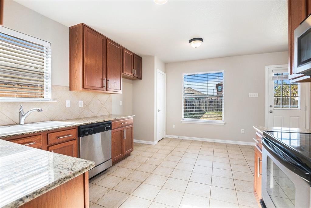8313 Water Buck Run Fort Worth, TX 76179 - Photo 10 of 25 a kitchen with stainless steel appliances granite countertop a sink stove and cabinets