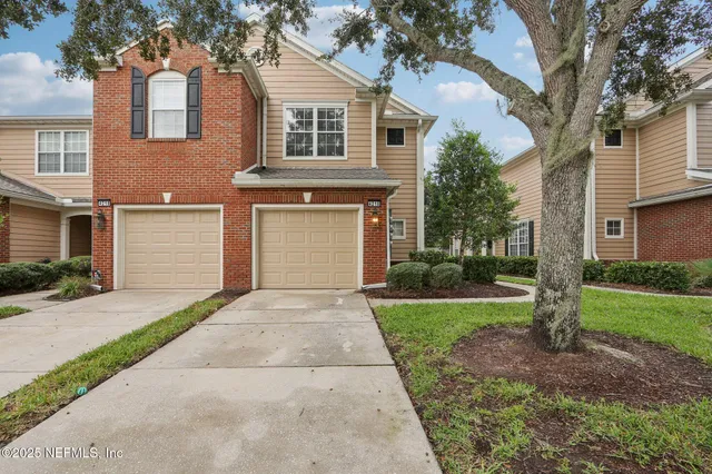 a front view of a house with a yard and a garage