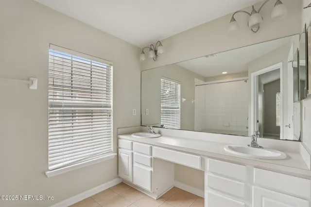 a bathroom with a double vanity sink and a mirror