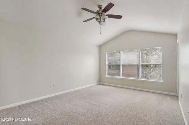 an empty room with a window and a fan