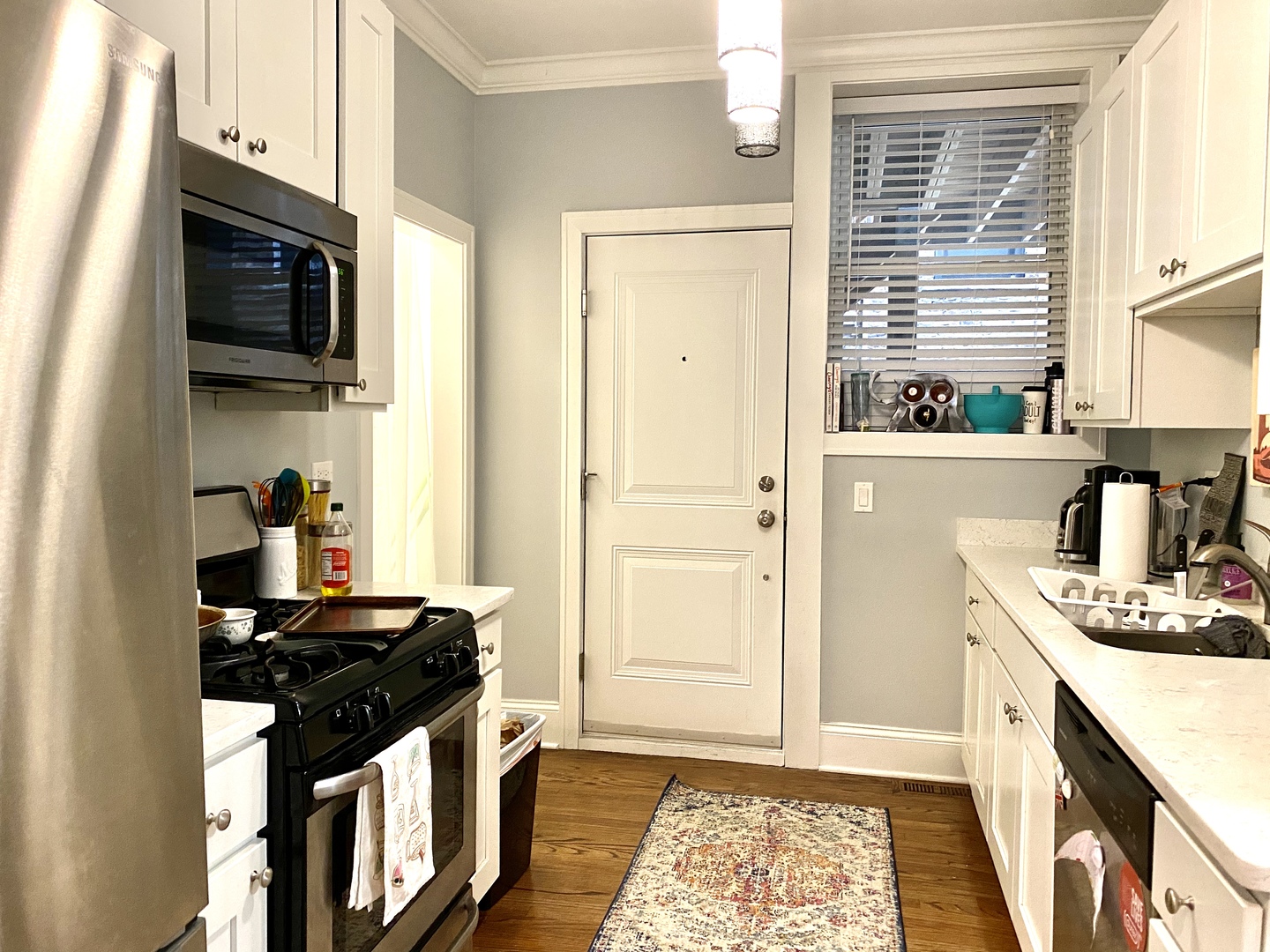 Undisclosed Address Chicago, IL 60657 - Photo 4 of 12 a kitchen with stainless steel appliances granite countertop a stove and a microwave