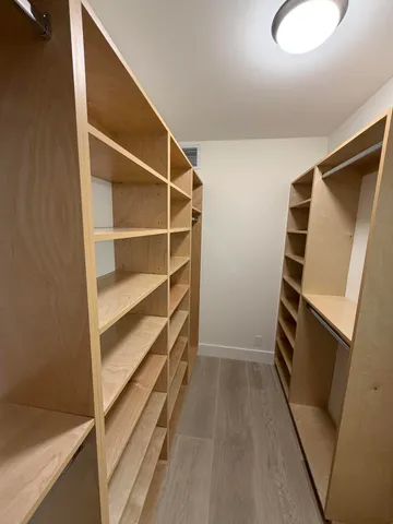 a view of walk in closet with empty racks