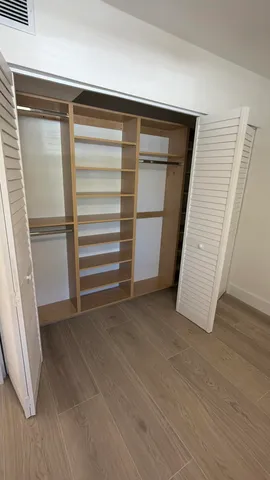 a view of walk in closet with empty racks