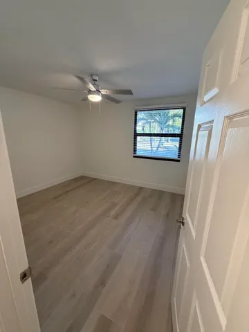 an empty room with windows and fan