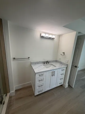 a bathroom with a granite countertop sink and a mirror