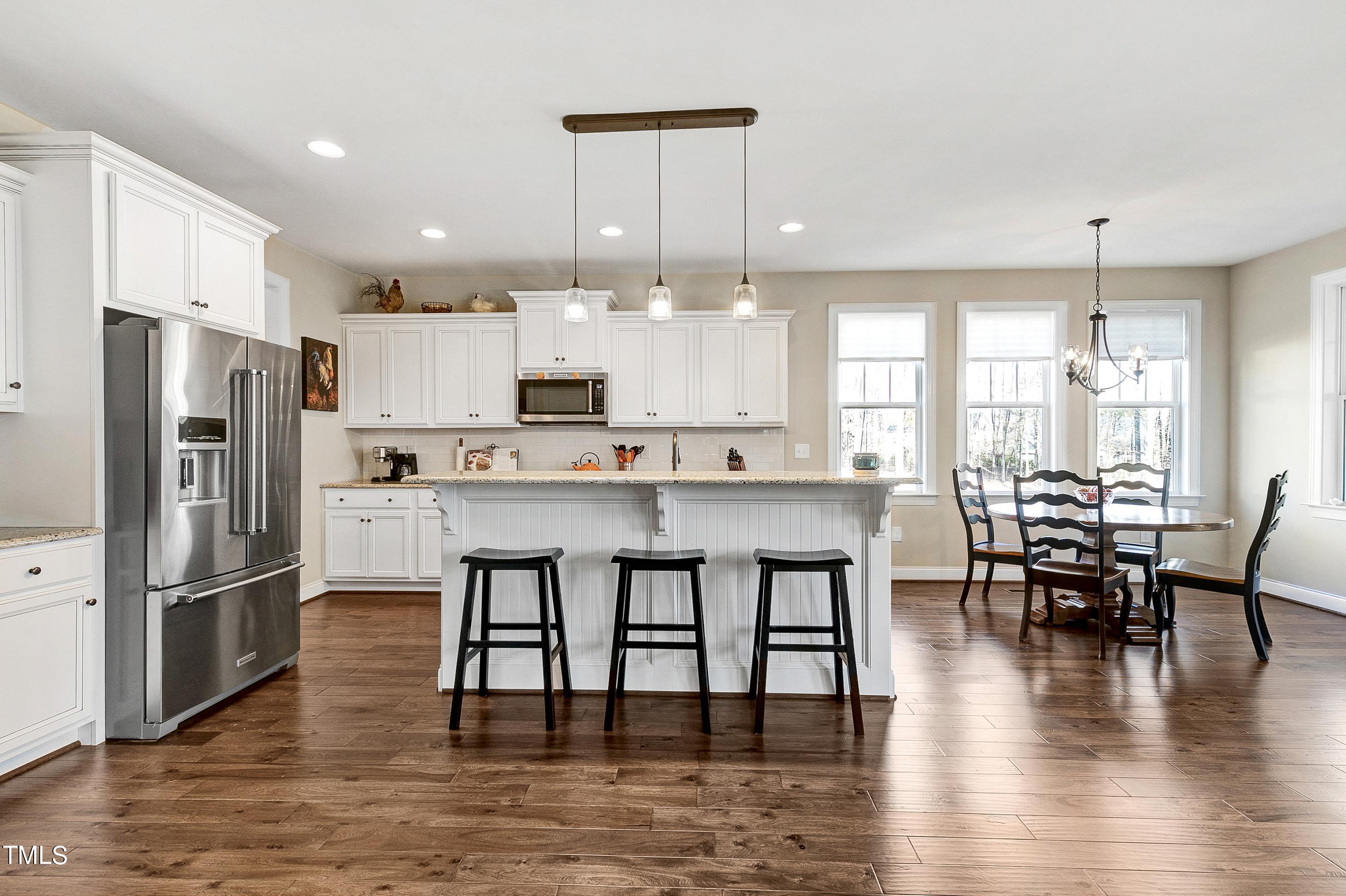 8533 Hurst Drive Raleigh, NC 27603 - Photo 3 of 43 a kitchen with stainless steel appliances granite countertop a dining table chairs refrigerator sink and microwave